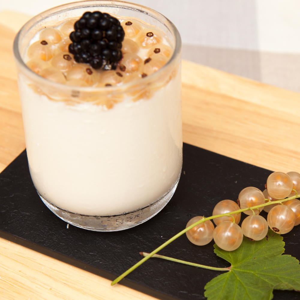 Dessert aux groseilles Cerise Blanche, mariant la douceur des fruits translucides et dorés avec une crème onctueuse.